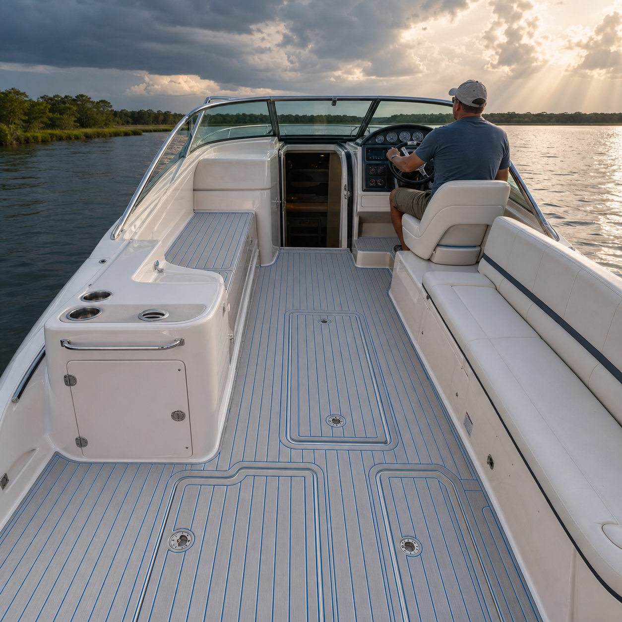 Open motorboat cockpit with a windshield, cabin doorway, helm seat, and light gray deck flooring with blue lines