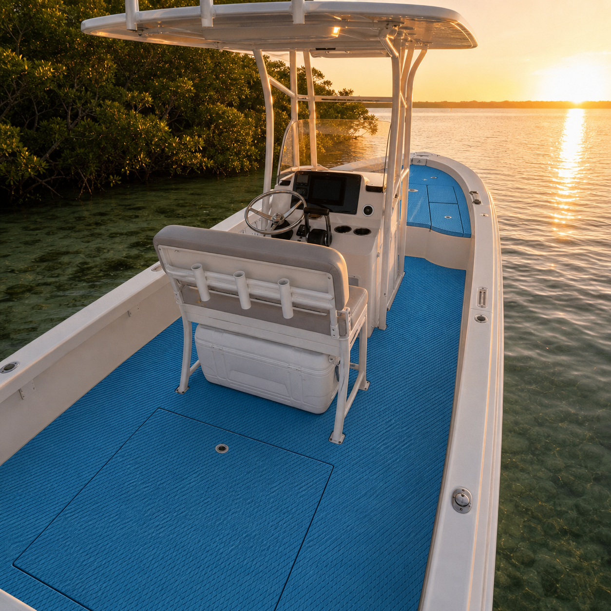 Blue textured flooring covers the deck of a white center-console fishing boat at sunset beside mangroves